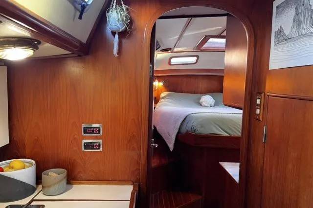 Slide: The Image of Cozy interior of 1988 Hylas Custom 44 sailboat with wood paneling and comfortable sleeping area. - 13