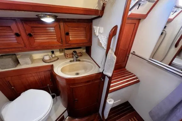 Slide: The Image of 1988 Hylas Custom 44 yacht bathroom with wooden cabinetry and compact sink. - 19