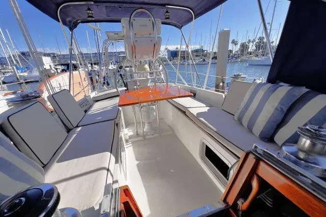 Slide: The Image of Cockpit of 1988 Hylas Custom 44 sailboat with cushioned seating and marina view. - 23