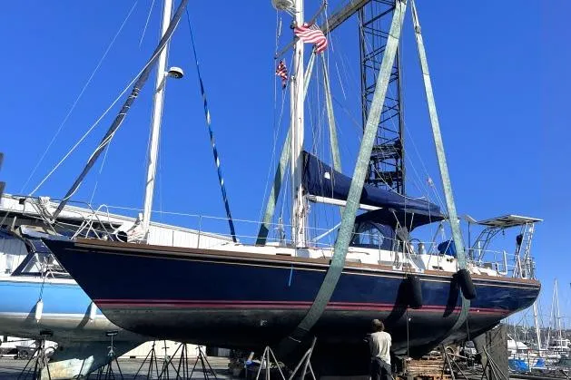 Slide: The Image of 1988 Hylas Custom 44 sailboat in dry dock, blue hull, marina background. - 47