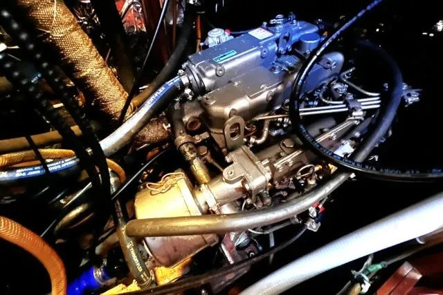 Slide: The Image of Engine compartment of 1988 Hylas Custom 44 sailboat, showcasing mechanical components and hoses. - 50
