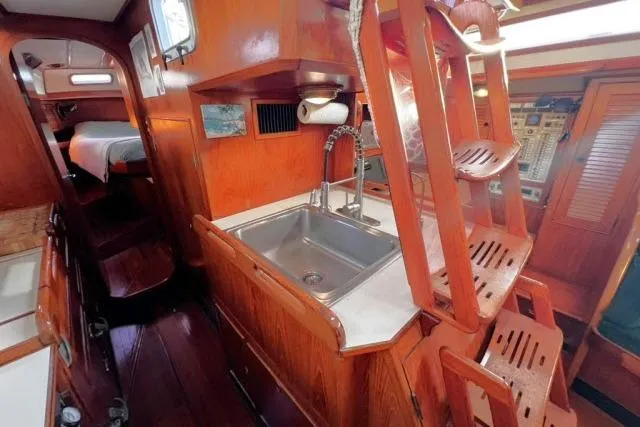 Slide: The Image of 1988 Hylas Custom 44 yacht interior with wooden cabinetry and compact kitchen sink. - 6