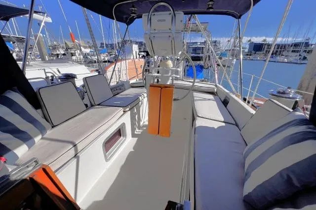 Slide: The Image of Cockpit of 1988 Hylas Custom 44 sailboat with cushioned seating and marina view. - 24