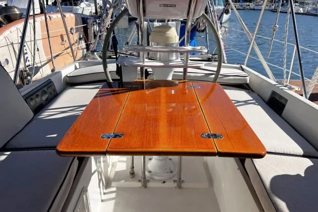 Slide: The Image of Cockpit of 1988 Hylas Custom 44 sailboat with polished wooden table and seating. - 25