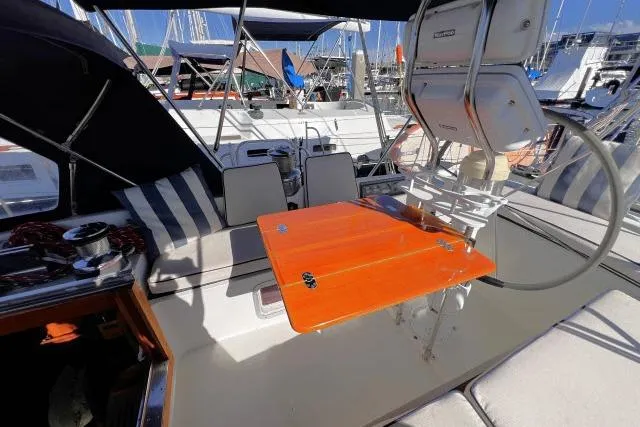 Slide: The Image of Cockpit of 1988 Hylas Custom 44 sailboat with orange table and striped seating. - 26