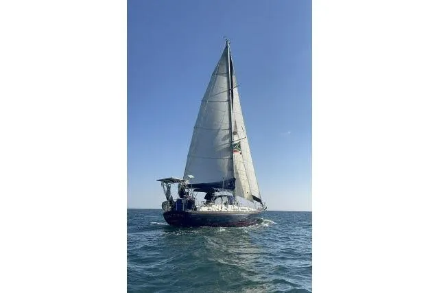 Slide: The Image of 1988 Hylas Custom 44 sailboat navigating on open sea under clear blue sky. - 43