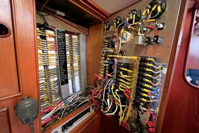 Slide: The Image of Electrical panel of 1988 Hylas Custom 44 sailboat with complex wiring and components. - 49