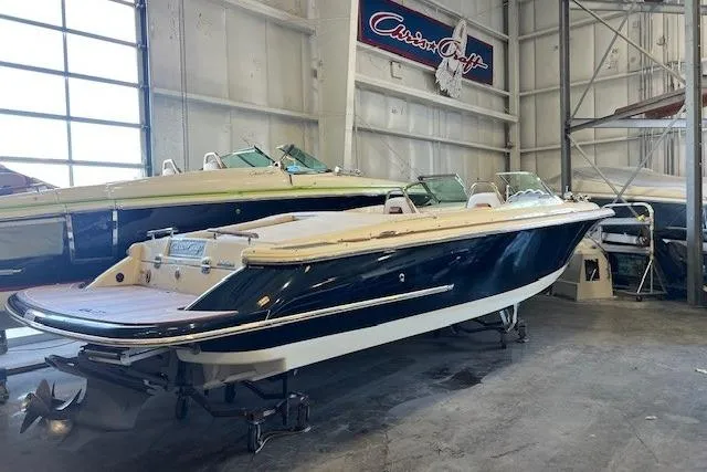 Slide: The Image of 2021 Chris-Craft Launch 27 boat in showroom, sleek design, navy hull, luxury features. - 9