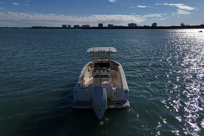 Slide: The Image of 2024 Scout 240 XSF boat on calm water under a clear sky. - 2