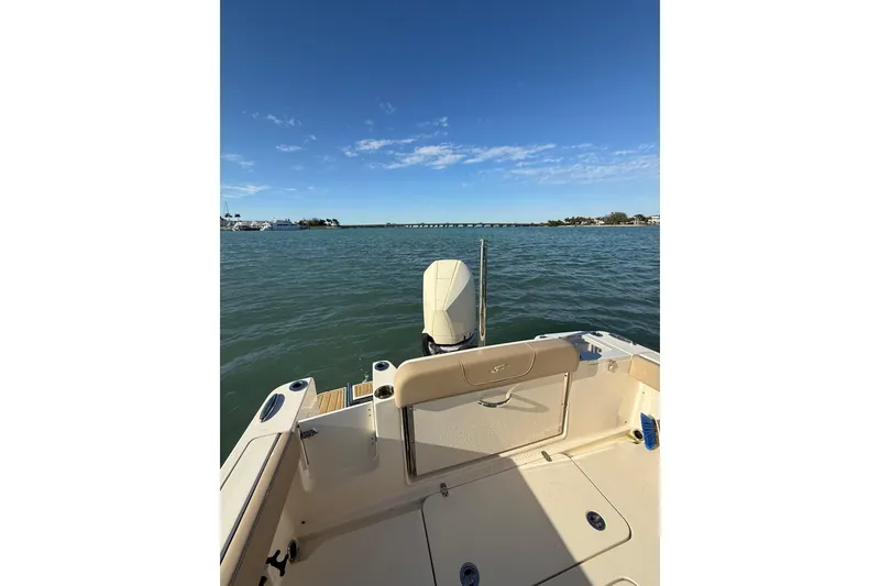 Slide: The Image of 2024 Scout 240 XSF boat on calm water under clear blue sky. - 6