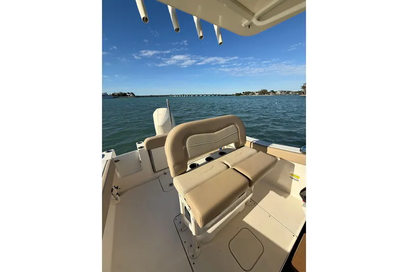 Slide: The Image of 2024 Scout 240 XSF boat interior with seating, overlooking calm waters and clear sky. - 8