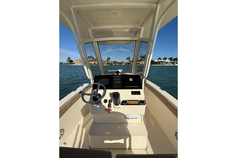 Slide: The Image of 2024 Scout 240 XSF boat cockpit with steering wheel and navigation system on open water. - 9