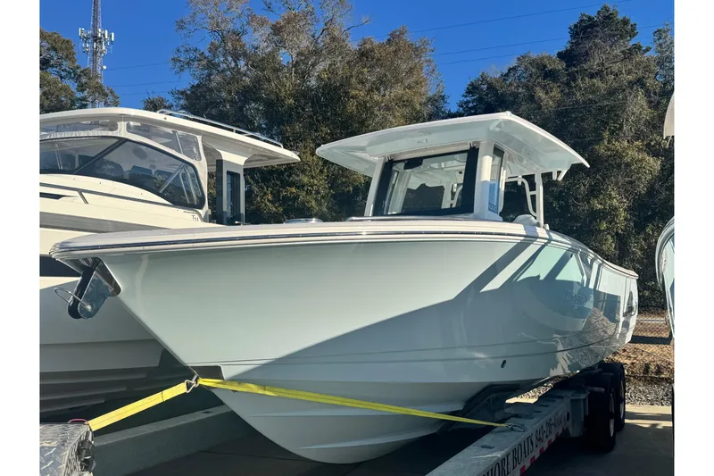 The Image of 2026 Robalo R300 Center Console boat on trailer, outdoors, sunny day. - 0