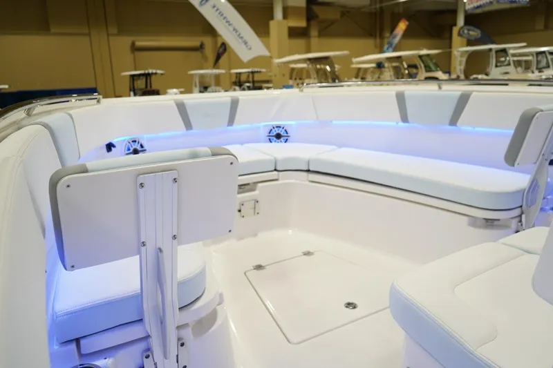 Slide: The Image of 2026 Robalo R300 Center Console boat interior with white seating and blue LED lighting. - 20