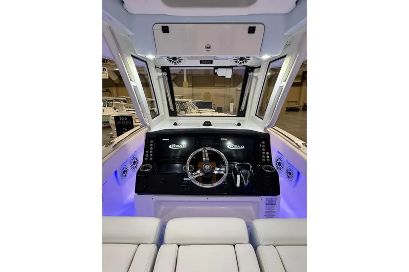 Slide: The Image of 2026 Robalo R300 Center Console boat interior with illuminated dashboard and steering wheel. - 5