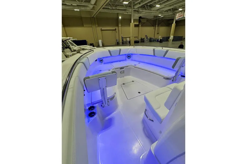 Slide: The Image of 2026 Robalo R300 Center Console boat interior with blue LED lighting and white seating. - 6