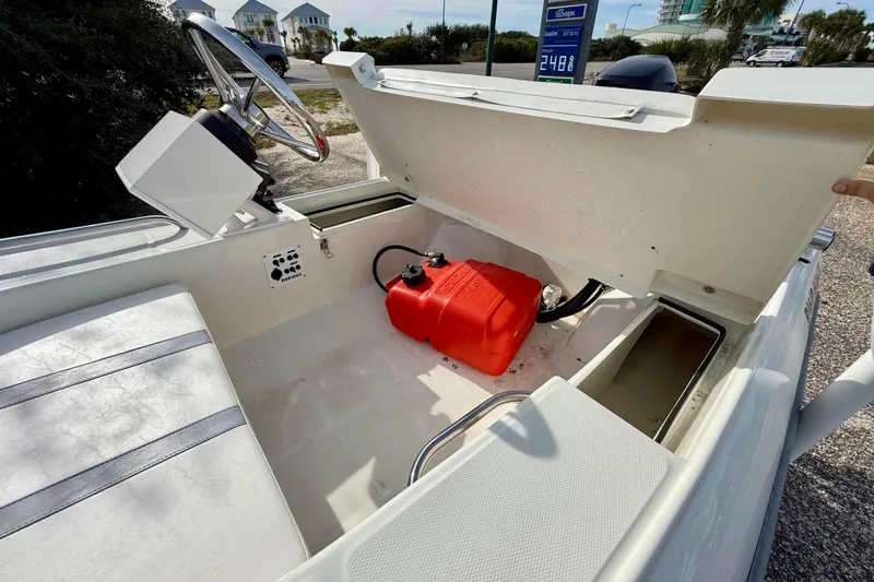 Slide: The Image of 2023 Rigid Boats 10 Sport interior with open storage compartment and red fuel tank. - 10