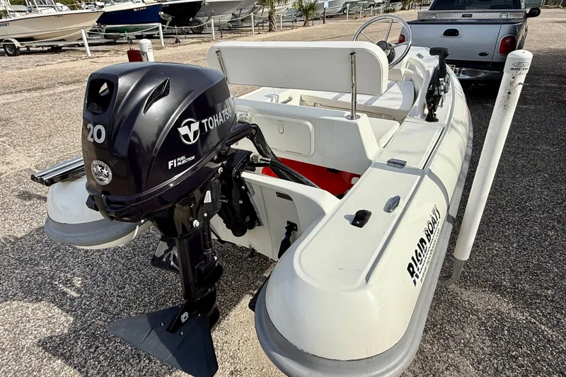 Slide: The Image of 2023 Rigid Boats 10 Sport with Tohatsu 20 engine, parked on gravel. - 3