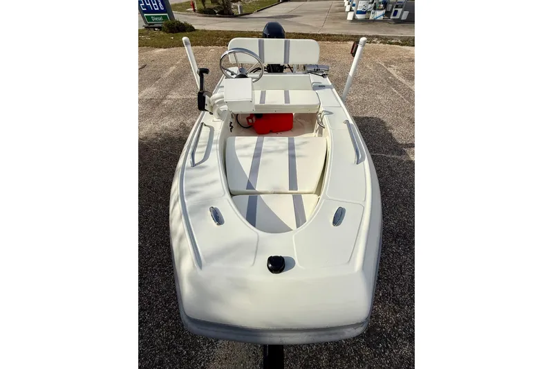 Slide: The Image of 2023 Rigid Boats 10 Sport, white, parked on gravel, featuring steering wheel and seating. - 7
