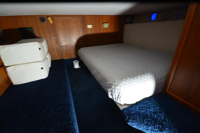 Slide: The Image of Cozy bedroom interior of 1994 Harbor Master 46 yacht with blue carpet and white bedding. - 2