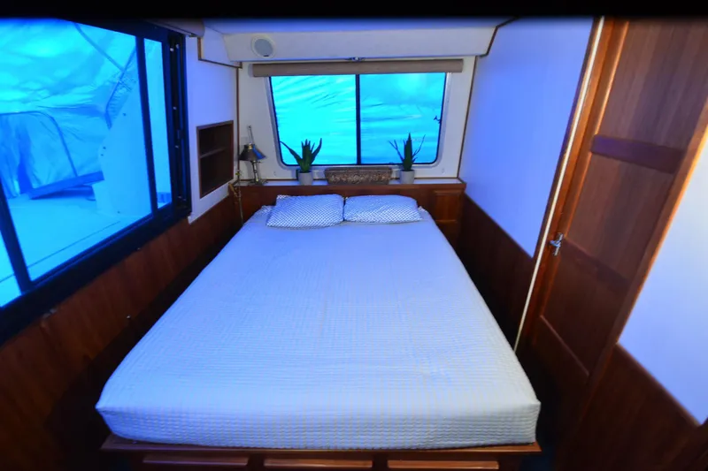 Slide: The Image of Cozy bedroom in 1994 Harbor Master 46 boat with large windows and wooden accents. - 20
