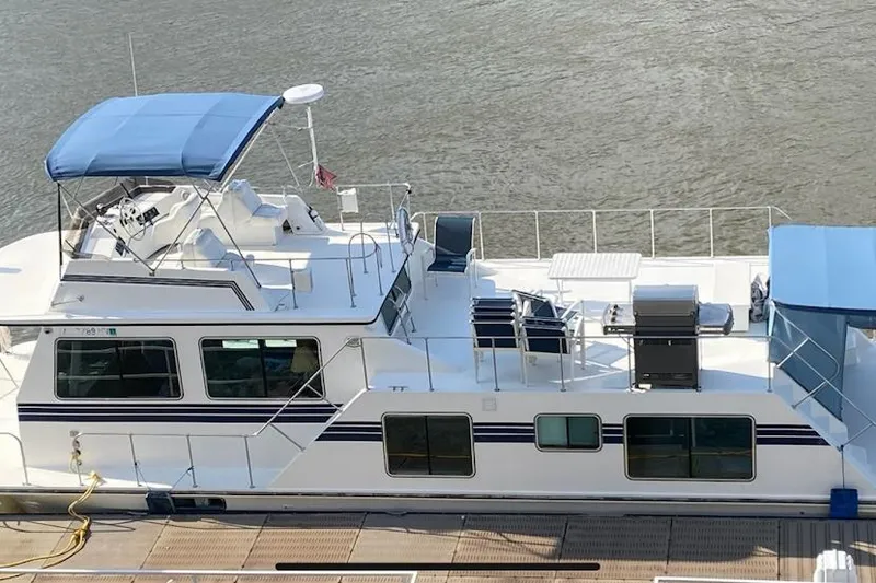 Slide: The Image of 1994 Harbor Master 46 houseboat docked with blue canopy. - 23