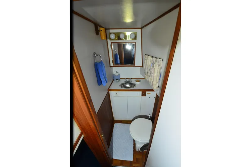 Slide: The Image of Bathroom interior of 1994 Harbor Master 46 boat, featuring sink, mirror, and toilet. - 4