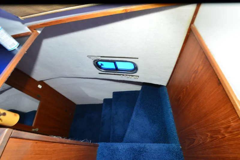 Slide: The Image of Interior stairs of 1994 Harbor Master 46 with blue carpet and wooden paneling. - 5