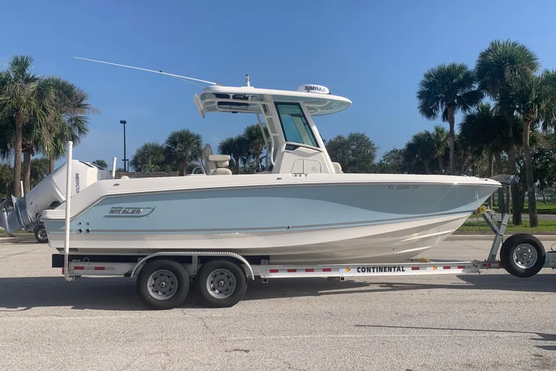 The Image of 2023 Boston Whaler 250 Outrage boat on trailer, parked with palm trees in background. - 0
