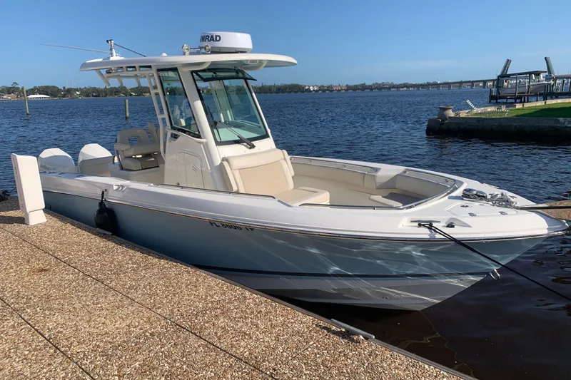 Slide: The Image of 2023 Boston Whaler 250 Outrage boat docked by the water. - 1