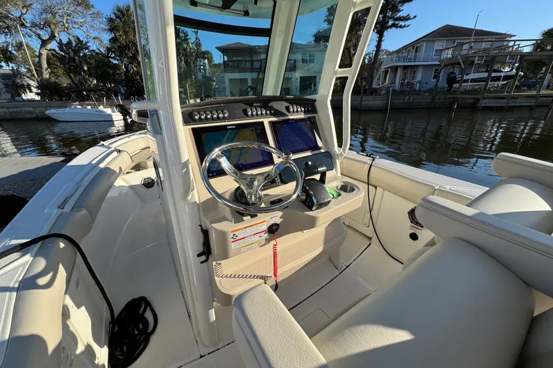 Slide: The Image of 2023 Boston Whaler 250 Outrage boat interior with modern helm and steering wheel. - 13