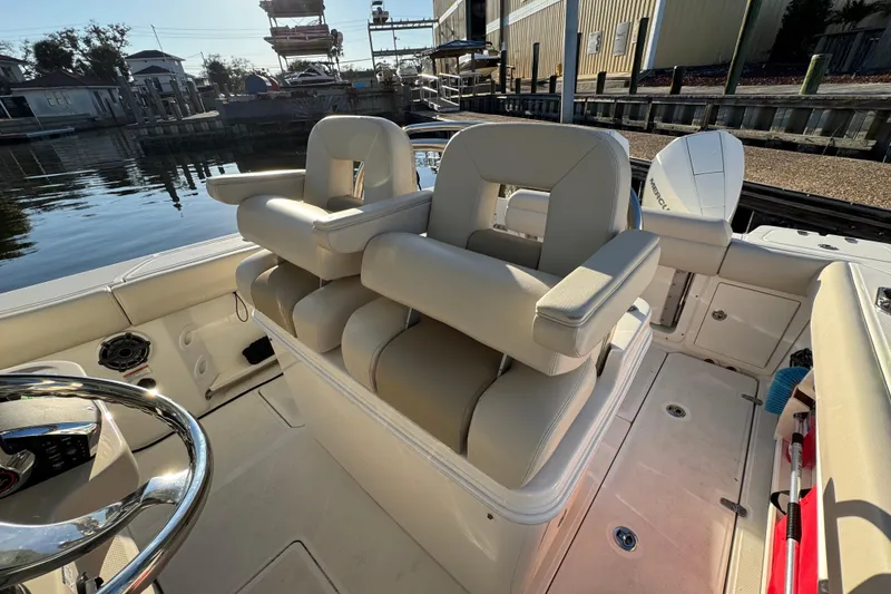 Slide: The Image of 2023 Boston Whaler 250 Outrage boat interior with plush seating and steering wheel. - 17