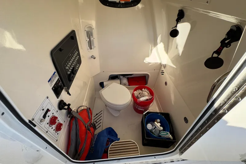 Slide: The Image of Interior of 2023 Boston Whaler 250 Outrage boat, featuring storage and control panel. - 19