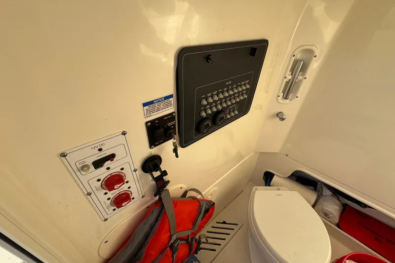 Slide: The Image of 2023 Boston Whaler 250 Outrage interior with control panel and marine toilet. - 20