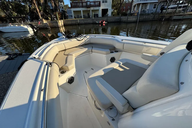 Slide: The Image of 2023 Boston Whaler 250 Outrage boat interior with seating and cup holders by the dock. - 21
