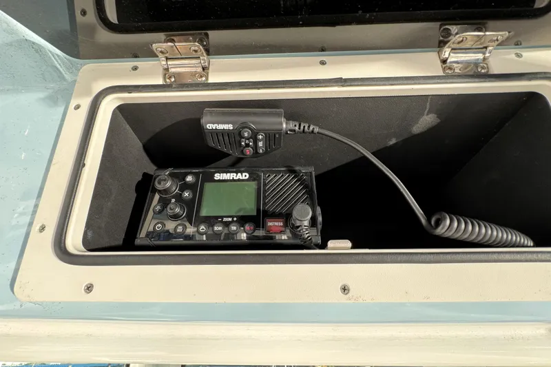Slide: The Image of Simrad marine radio in storage compartment of 2023 Boston Whaler 250 Outrage boat. - 28