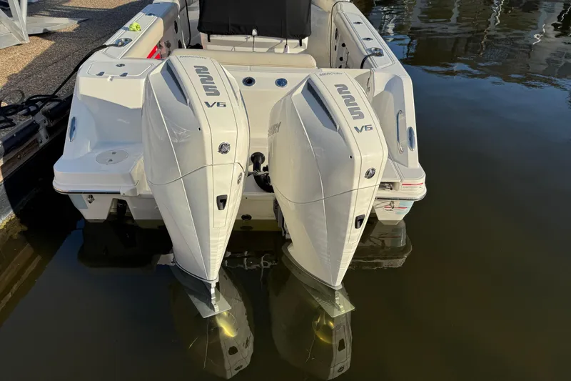 Slide: The Image of 2023 Boston Whaler 250 Outrage with dual Mercury V6 engines docked in water. - 4