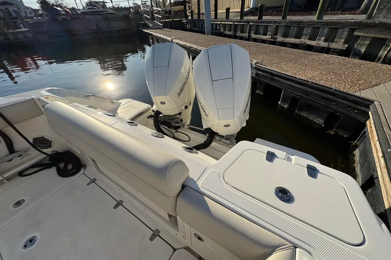 Slide: The Image of 2023 Boston Whaler 250 Outrage boat with dual Mercury engines docked by the water. - 9
