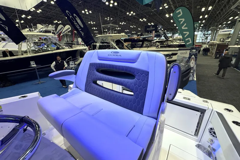 Slide: The Image of 2026 Cobia 245 Center Console boat seat at a boat show display. - 10