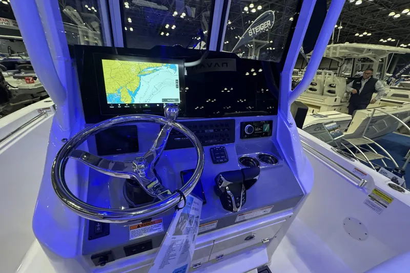 Slide: The Image of 2026 Cobia 245 Center Console boat dashboard with navigation display and controls. - 12