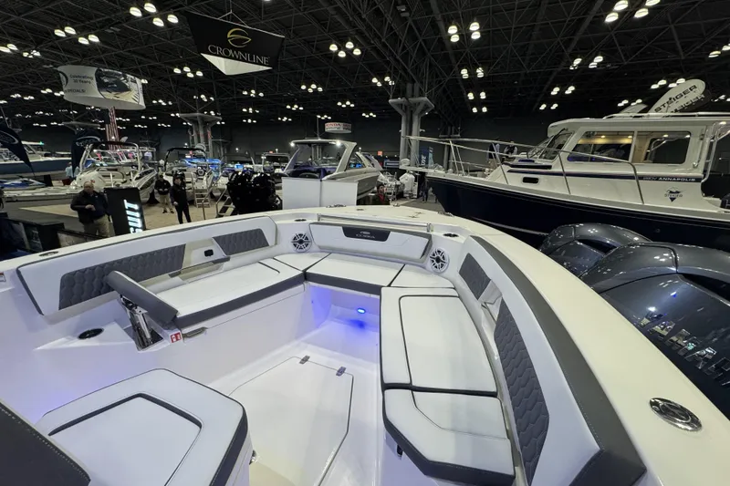 Slide: The Image of 2026 Cobia 245 Center Console boat interior at a boat show, featuring spacious seating. - 16