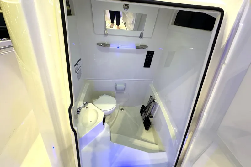 Slide: The Image of 2026 Cobia 245 Center Console boat interior with compact bathroom amenities. - 17