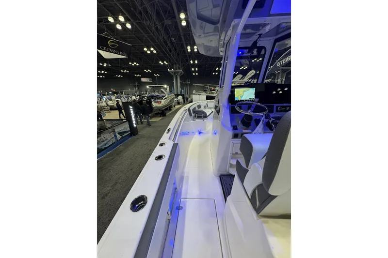 Slide: The Image of 2026 Cobia 245 Center Console boat interior at a boat show, featuring modern design and lighting. - 18