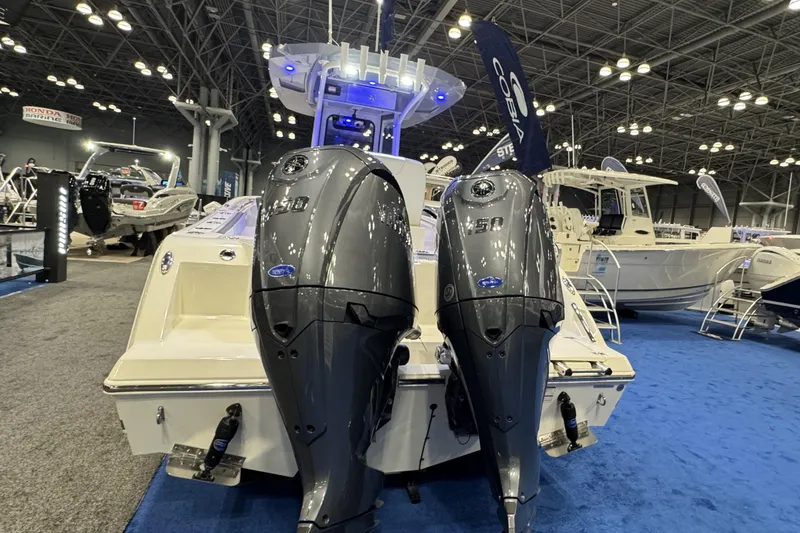 Slide: The Image of 2026 Cobia 245 Center Console boat with dual outboard engines at a boat show. - 3
