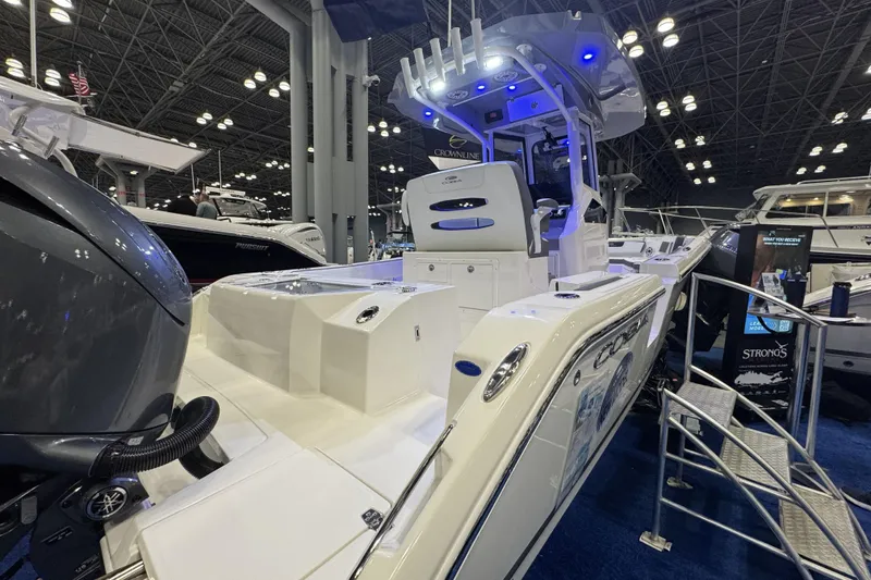Slide: The Image of 2026 Cobia 245 Center Console boat displayed at an indoor boat show. - 4