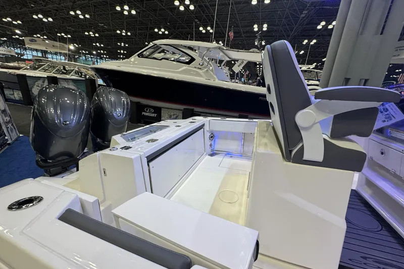 Slide: The Image of 2026 Cobia 245 Center Console boat interior with dual engines at a boat show. - 6