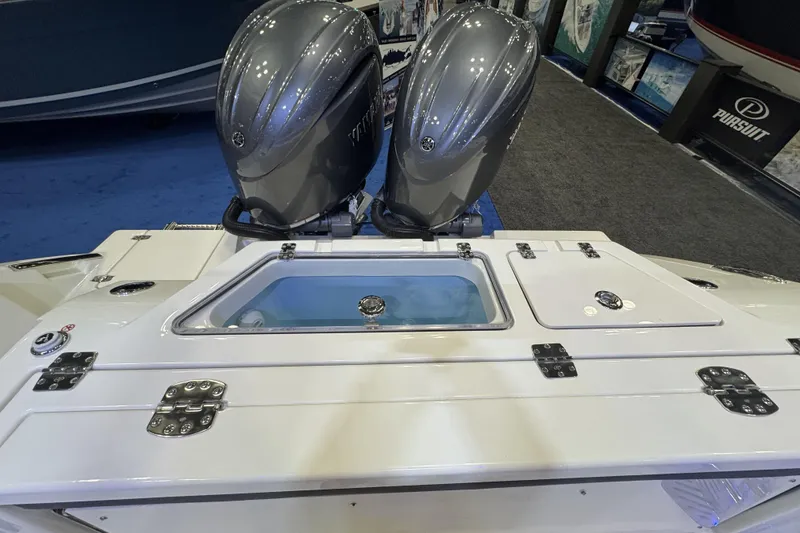 Slide: The Image of 2026 Cobia 245 Center Console with dual outboard engines at a boat show display. - 7