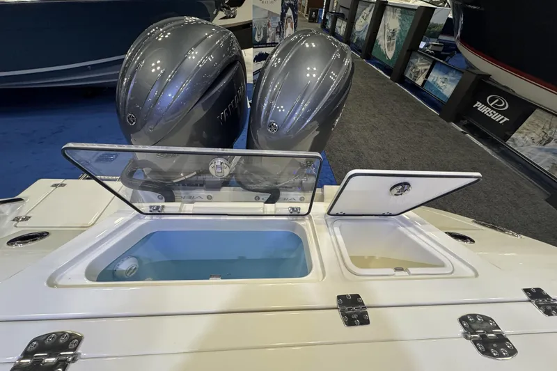 Slide: The Image of 2026 Cobia 245 Center Console boat with open storage compartments and dual engines. - 8