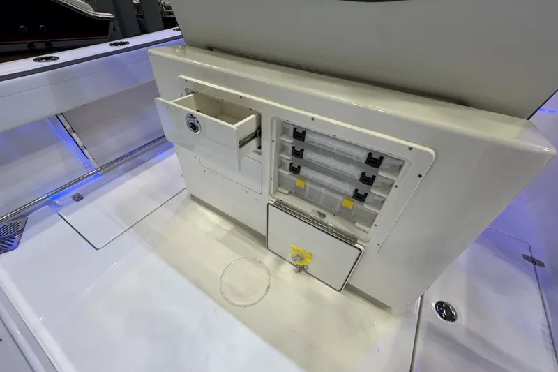 Slide: The Image of 2026 Cobia 245 Center Console boat storage compartments with drawers and tackle boxes. - 9