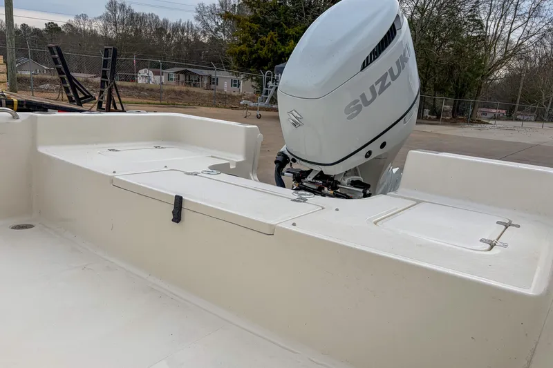 Slide: The Image of 2026 Bulls Bay 2400 boat with Suzuki outboard motor in a parking area. - 4